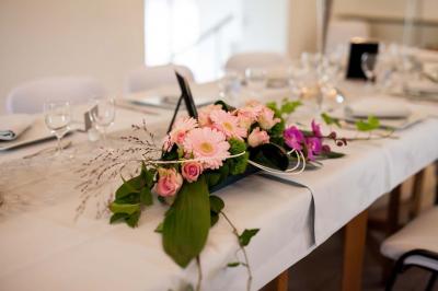 Vue aérienne d'un complexe avec plusieurs bâtiments, un jardin central, un parking et des zones identifiées par des noms.