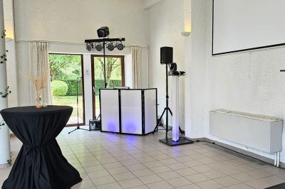 Vue aérienne d'un complexe avec plusieurs bâtiments, un jardin central, un parking et des zones identifiées par des noms.