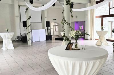 Vue aérienne d'un complexe avec plusieurs bâtiments, un jardin central, un parking et des zones identifiées par des noms.