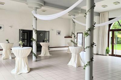 Vue aérienne d'un complexe avec plusieurs bâtiments, un jardin central, un parking et des zones identifiées par des noms.