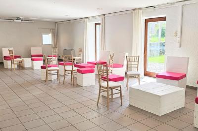 Vue aérienne d'un complexe avec plusieurs bâtiments, un jardin central, un parking et des zones identifiées par des noms.