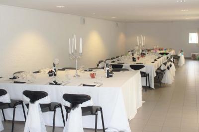 Vue aérienne d'un complexe avec plusieurs bâtiments, un jardin central, un parking et des zones identifiées par des noms.