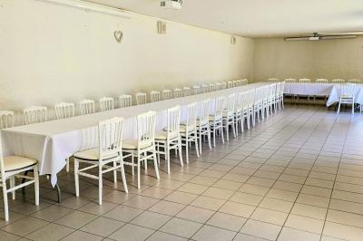 Vue aérienne d'un complexe avec plusieurs bâtiments, un jardin central, un parking et des zones identifiées par des noms.