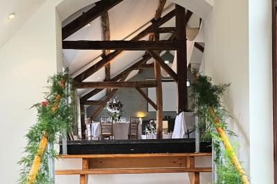 Vue aérienne d'un complexe avec plusieurs bâtiments, un jardin central, un parking et des zones identifiées par des noms.