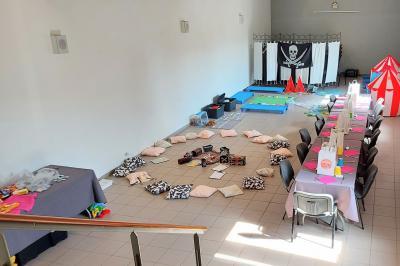 Miniature Salle 5 : espace enfants Vue aérienne d'un complexe avec plusieurs bâtiments, un jardin central, un parking et des zones identifiées par des noms.