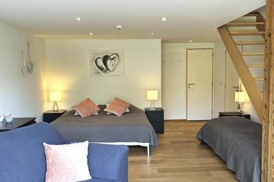 Vue aérienne d'un complexe avec plusieurs bâtiments, un jardin central, un parking et des zones identifiées par des noms.