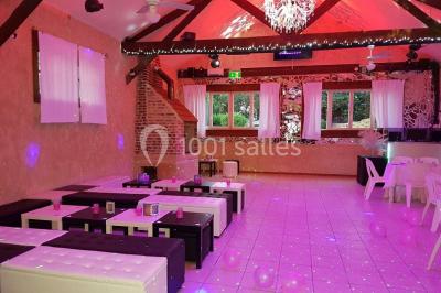 Miniature Location salle Beaudéduit (Oise) - LFK Réceptions #5 Pièce montée en forme d'anneaux entrelacés avec des figurines de mariés, entourée de bouteilles de champagne.