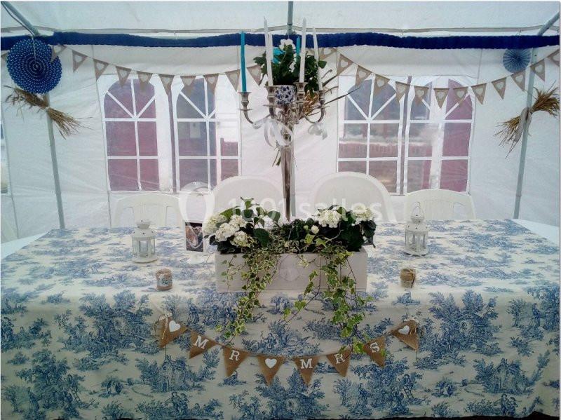 Location salle Beaudéduit (Oise) - LFK Réceptions #10 Table décorée pour un mariage sous une tente, avec nappe bleue et blanche, guirlandes, fleurs et bougies.