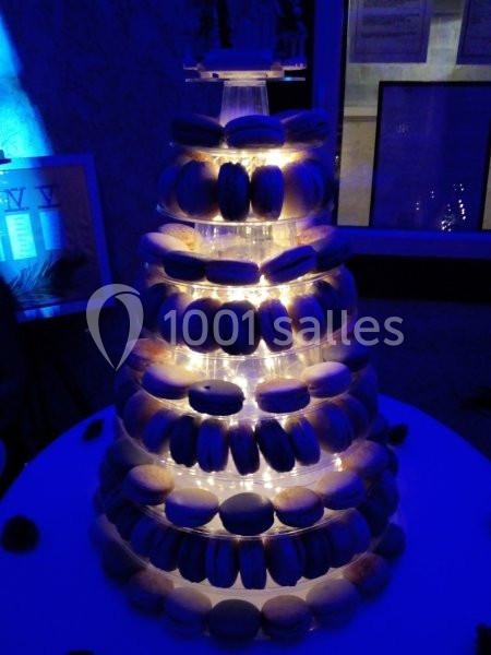 Location salle Beaudéduit (Oise) - LFK Réceptions #17 Tour de macarons éclairée sur une table ronde dans un environnement sombre.