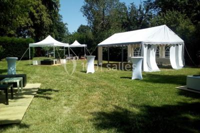 Miniature Location salle Beaudéduit (Oise) - LFK Réceptions #4 Pièce montée en forme d'anneaux entrelacés avec des figurines de mariés, entourée de bouteilles de champagne.