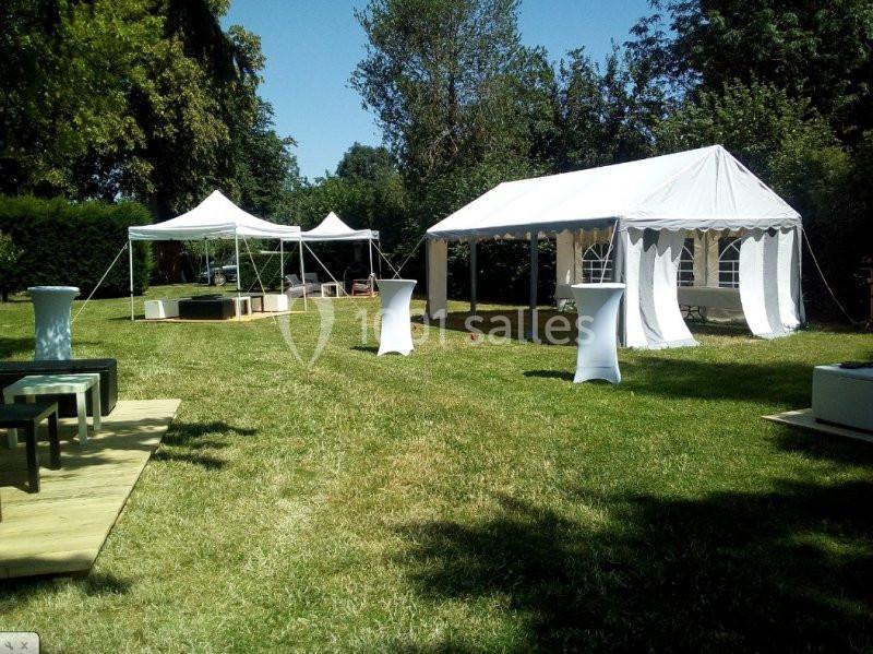 Location salle Beaudéduit (Oise) - LFK Réceptions #4 Tentes blanches installées sur une pelouse pour un événement en extérieur, entourées d'arbres et de mobilier.