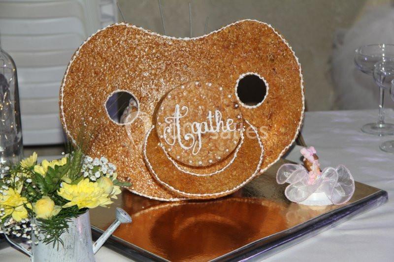 Location salle Beaudéduit (Oise) - LFK Réceptions #22 Pièce montée en forme de tétine avec le prénom ’Agathe’, décorée de perles de sucre, posée sur une table festive.