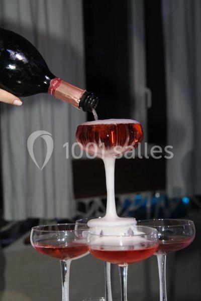 Location salle Beaudéduit (Oise) - LFK Réceptions #18 Du vin pétillant rosé est versé dans une coupe, débordant pour remplir d'autres verres en cascade.