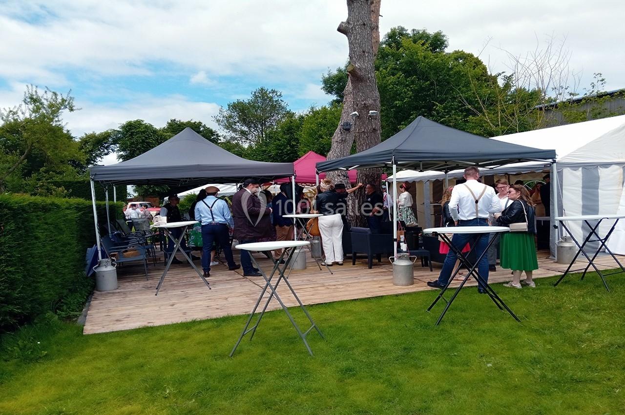 Location salle Beaudéduit (Oise) - LFK Réceptions #3 Personnes rassemblées sous des tonnelles dans un jardin, discutant autour de tables hautes lors d'un événement en plein air.
