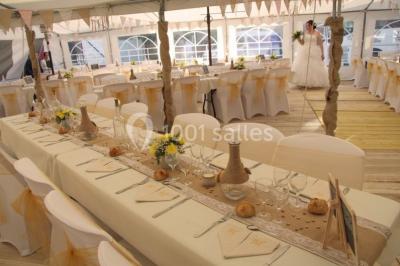 Miniature Barnums professionnels Pièce montée en forme d'anneaux entrelacés avec des figurines de mariés, entourée de bouteilles de champagne.