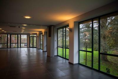 Miniature Location salle Anhée (Namur) - Salle des Jardins de la Molignee #9 Salle vide avec de grandes baies vitrées donnant sur un espace vert, éclairée par une lumière douce.