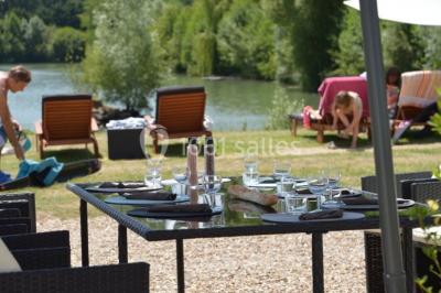 Quatre femmes pratiquant le yoga en posture de l'arbre sur des tapis colorés dans un espace extérieur herbeux.