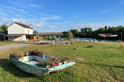 Quatre femmes pratiquant le yoga en posture de l'arbre sur des tapis colorés dans un espace extérieur herbeux.