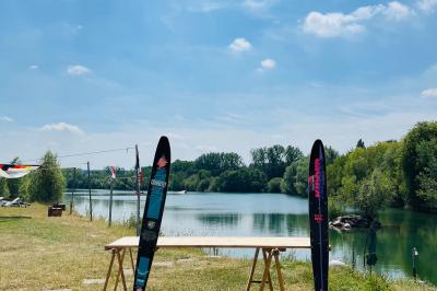 Quatre femmes pratiquant le yoga en posture de l'arbre sur des tapis colorés dans un espace extérieur herbeux.