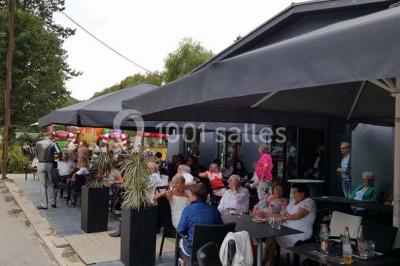 Miniature Location salle Fampoux (Pas-de-Calais) - L'hermitage de Fampoux #7 Salle sombre avec éclairage violet, plafond métallique, tables et chaises dispersées sur un sol à carreaux.