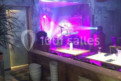 Miniature Location salle Fampoux (Pas-de-Calais) - L'hermitage de Fampoux #10 Salle sombre avec éclairage violet, plafond métallique, tables et chaises dispersées sur un sol à carreaux.