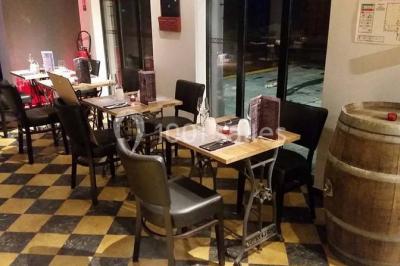 Miniature Location salle Fampoux (Pas-de-Calais) - L'hermitage de Fampoux #12 Salle sombre avec éclairage violet, plafond métallique, tables et chaises dispersées sur un sol à carreaux.