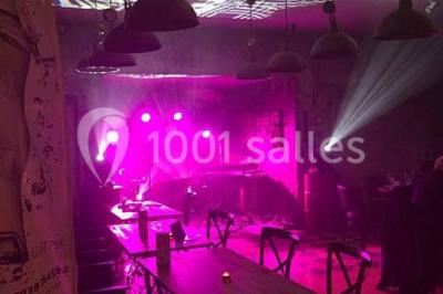 Miniature Location salle Fampoux (Pas-de-Calais) - L'hermitage de Fampoux #9 Salle sombre avec éclairage violet, plafond métallique, tables et chaises dispersées sur un sol à carreaux.