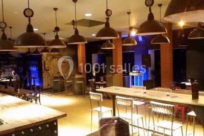 Miniature Location salle Fampoux (Pas-de-Calais) - L'hermitage de Fampoux #17 Salle sombre avec éclairage violet, plafond métallique, tables et chaises dispersées sur un sol à carreaux.