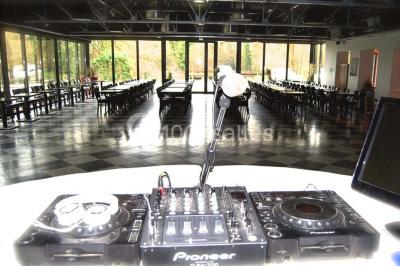 Miniature Location salle Fampoux (Pas-de-Calais) - L'hermitage de Fampoux #16 Salle sombre avec éclairage violet, plafond métallique, tables et chaises dispersées sur un sol à carreaux.