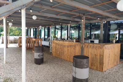 Miniature Location salle Fampoux (Pas-de-Calais) - L'hermitage de Fampoux #4 Salle sombre avec éclairage violet, plafond métallique, tables et chaises dispersées sur un sol à carreaux.