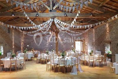 Miniature Location salle Chambost-Allières (Rhône) - Domaine de Montfriol #1 Structure en bois avec décorations de mariage, incluant des lettres blanches, un tonneau et des fleurs suspendues.