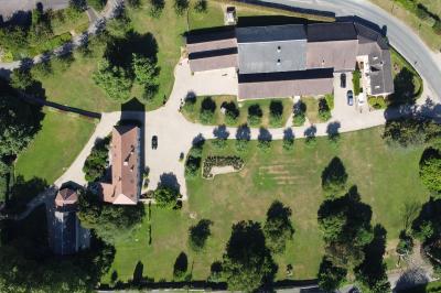 Miniature Location salle La Chapelle-Réanville (Eure) - Le Manoir de La Chapelle #16 Vue aérienne d'un domaine avec bâtiments, allées, jardins et espaces verts entourés d'arbres.