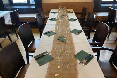 Miniature Location salle Villeurbanne (Rhône) - Sapristi #8 Table de restaurant dressée avec nappes noires et grises, verres, couverts, serviettes pliées et menu au centre.