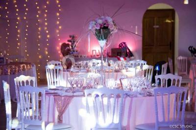 Allée bordée de cyprès et de vignes avec une vue sur une montagne en arrière-plan, sous un ciel clair.