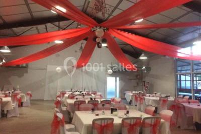 Table de pique-nique en bois sur un sol de gravier, entourée d'arbres dans un cadre naturel.
