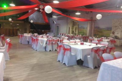 Table de pique-nique en bois sur un sol de gravier, entourée d'arbres dans un cadre naturel.