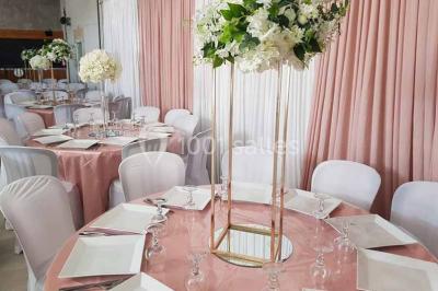 Table de pique-nique en bois sur un sol de gravier, entourée d'arbres dans un cadre naturel.