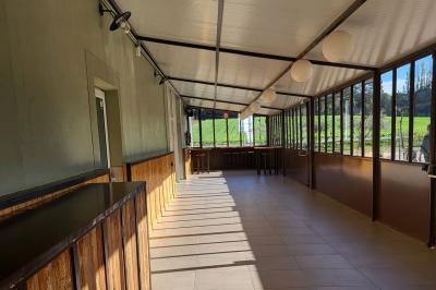 Table de pique-nique en bois sur un sol de gravier, entourée d'arbres dans un cadre naturel.