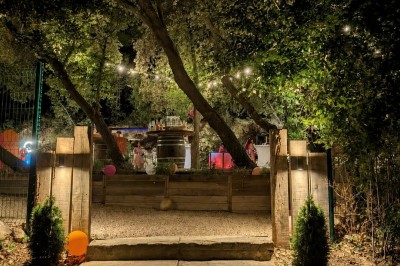 Miniature Location salle Loriol-du-Comtat (Vaucluse) - La Maelia #28 Espace extérieur décoré pour un événement avec tables hautes, ballons colorés et guirlandes lumineuses sous des arbres.
