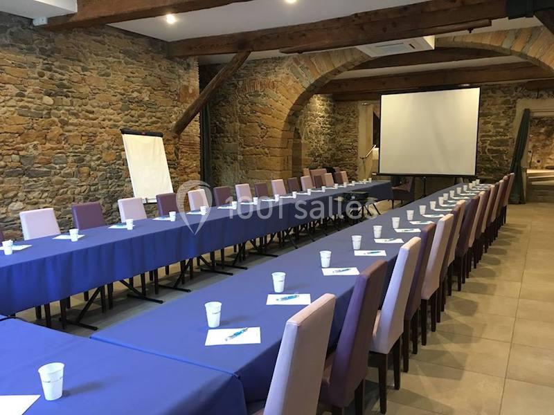 Location salle Lyon 9 (Rhône) - Hub de l'Ile Barbe #6 Salle de réunion avec longues tables couvertes de nappes bleues, chaises alignées, écran de projection et paperboard.