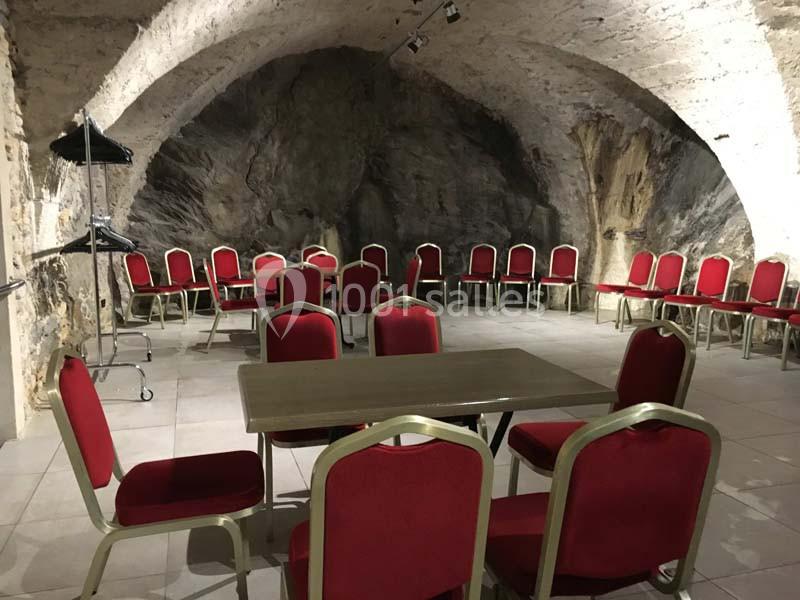 Location salle Lyon 9 (Rhône) - Hub de l'Ile Barbe #16 Salle voûtée en pierre avec des chaises rouges disposées autour d'une table centrale et sur les côtés.