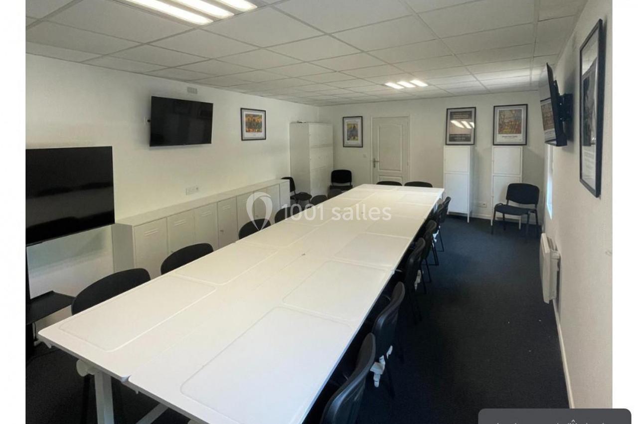 Location salle Lyon 9 (Rhône) - Hub de l'Ile Barbe #15 Salle de réunion lumineuse avec une grande table rectangulaire, des chaises noires et des écrans muraux.