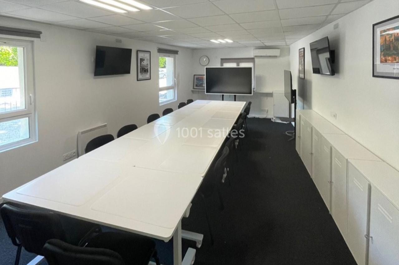 Location salle Lyon 9 (Rhône) - Hub de l'Ile Barbe #20 Salle de réunion lumineuse avec une grande table blanche, des chaises noires, des écrans muraux et des fenêtres.