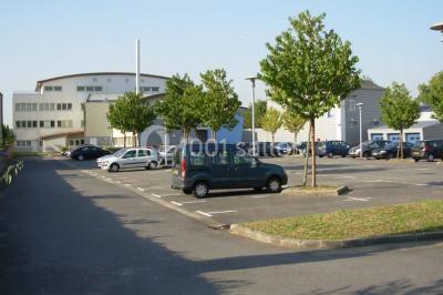 Miniature Location salle Rouen (Seine-Maritime) - Union Portuaire Rouennaise #18 Parking extérieur avec quelques voitures stationnées, entouré de bâtiments modernes et d'arbres alignés.