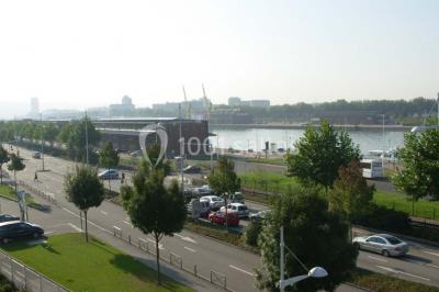 Miniature Location salle Rouen (Seine-Maritime) - Union Portuaire Rouennaise #16 Parking extérieur avec quelques voitures stationnées, entouré de bâtiments modernes et d'arbres alignés.