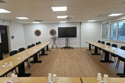 Miniature Location salle Rouen (Seine-Maritime) - Union Portuaire Rouennaise #5 Parking extérieur avec quelques voitures stationnées, entouré de bâtiments modernes et d'arbres alignés.