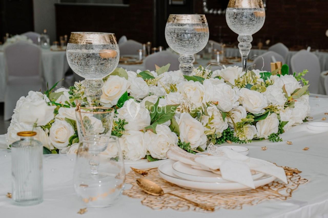 Table décorée avec des fleurs blanches, des verres élégants et une vaisselle raffinée dans un cadre de réception.