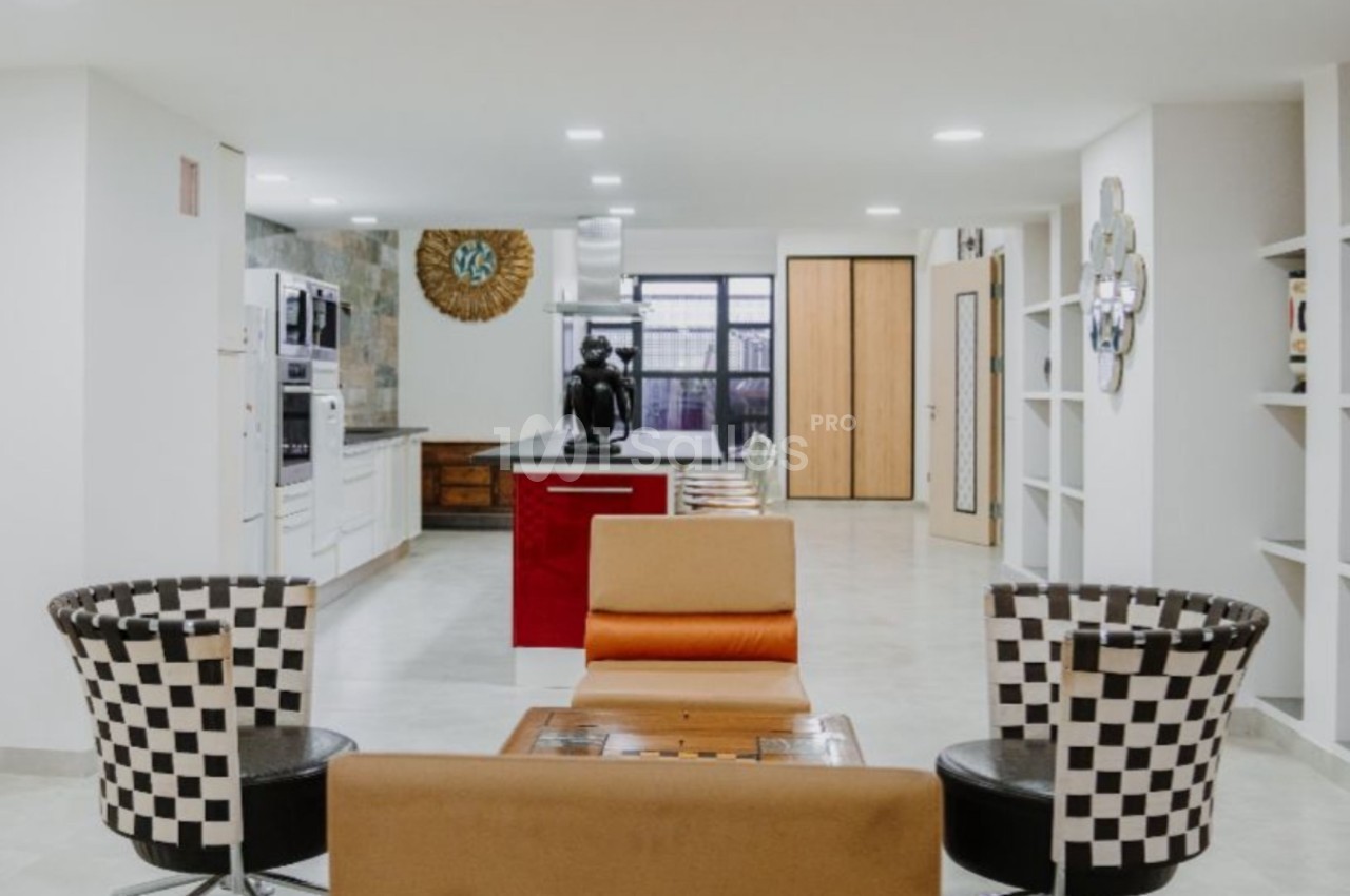 Espace intérieur lumineux avec coin salon, cuisine ouverte moderne et mobilier au design contemporain.