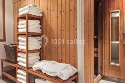 Salle de restaurant lumineuse avec des tables en bois, chaises bleues et grandes fenêtres laissant entrer la lumière…
