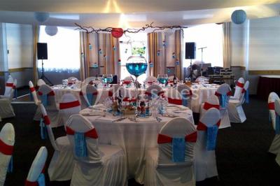 Salle de restaurant lumineuse avec des tables en bois, chaises bleues et grandes fenêtres laissant entrer la lumière…